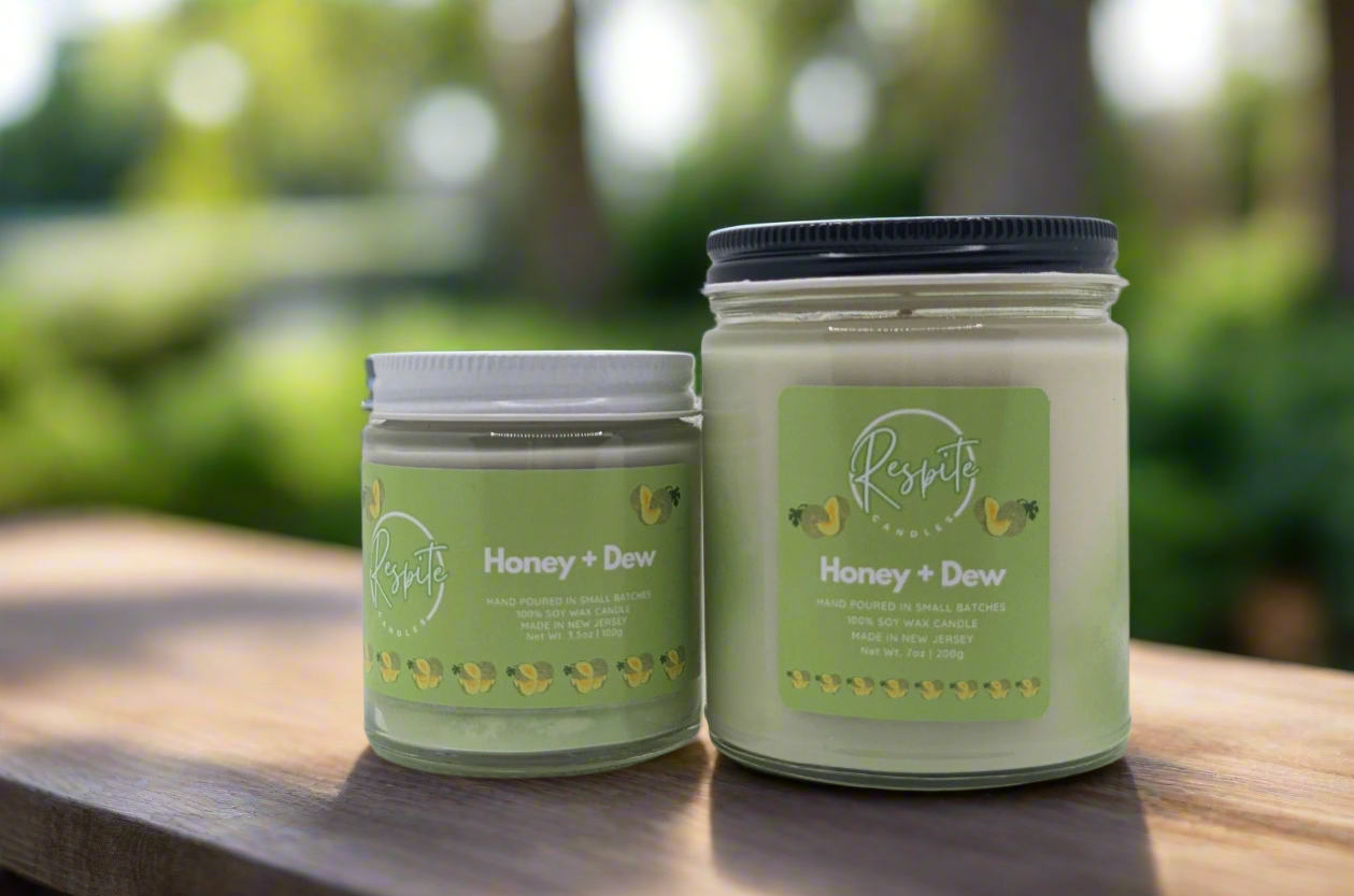 Two jars of 'Honey + Dew' candle on a white background