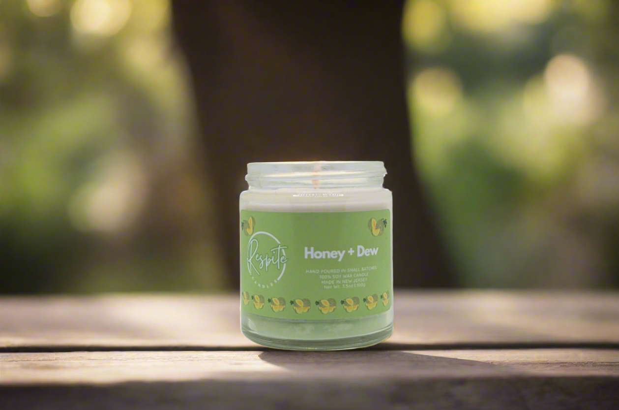 Candle in a glass jar with a green label on a white background