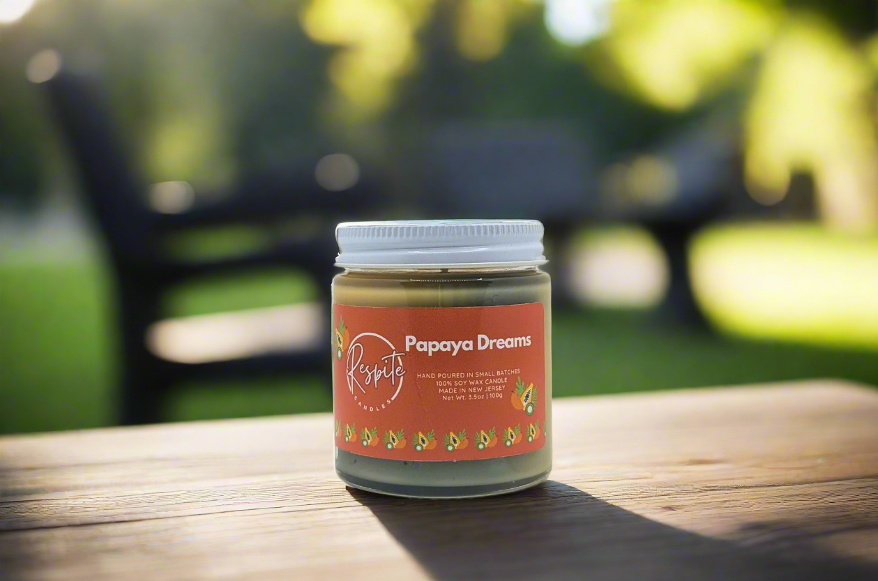 Jar of 'Papaya Dreams' candle on a white background