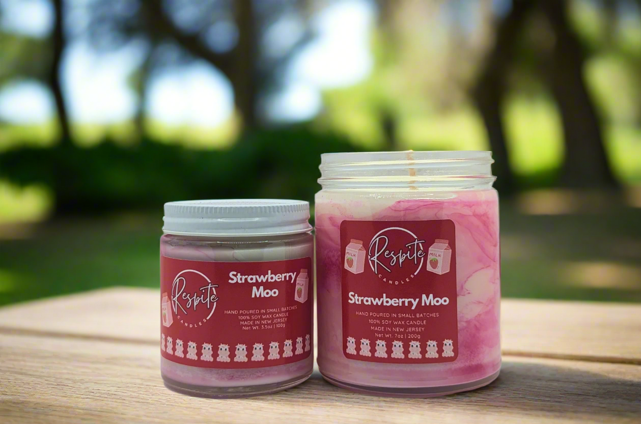 Two strawberry moo candles on a white background