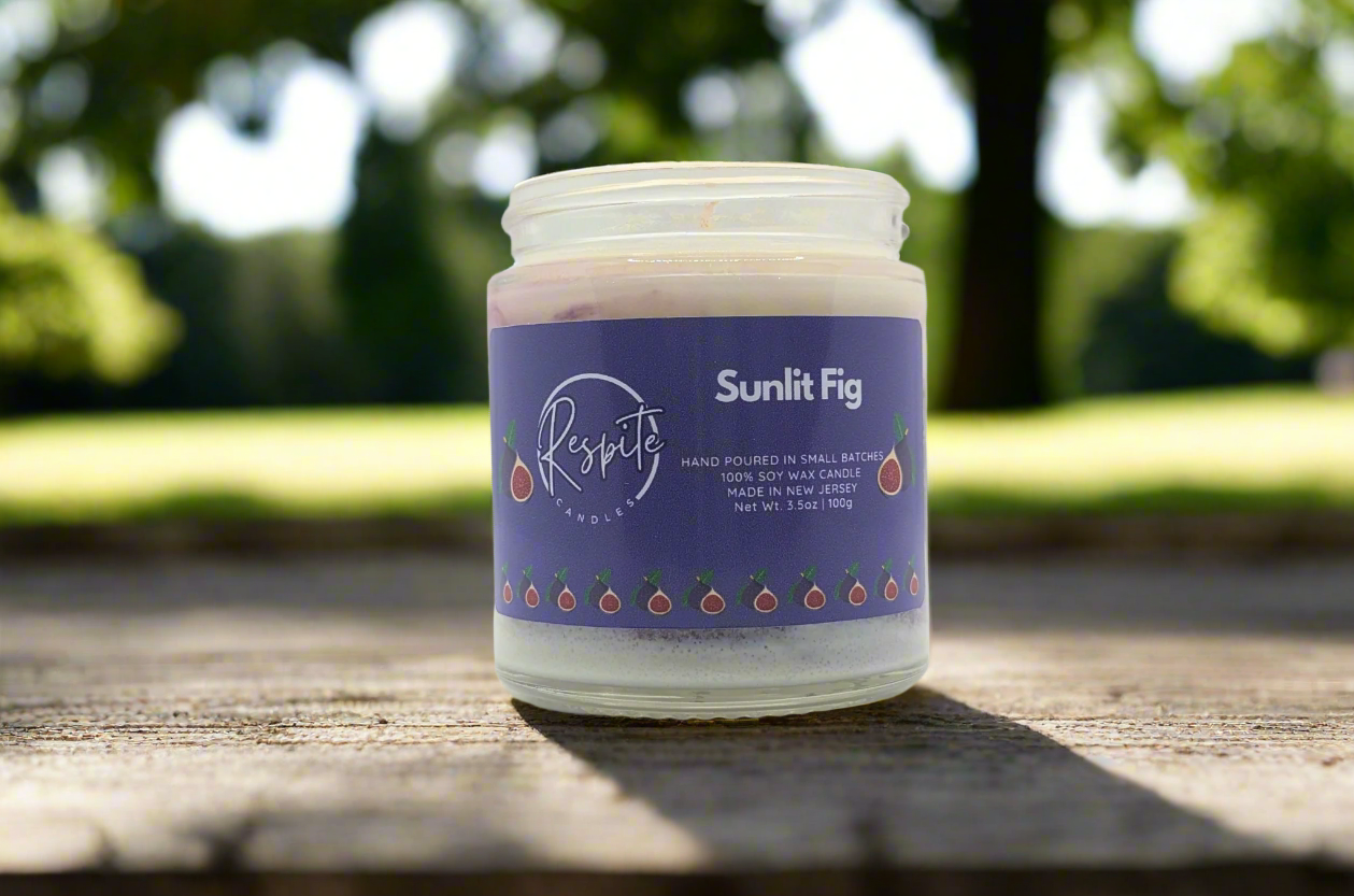 Candle in a glass jar with a purple label on a white background