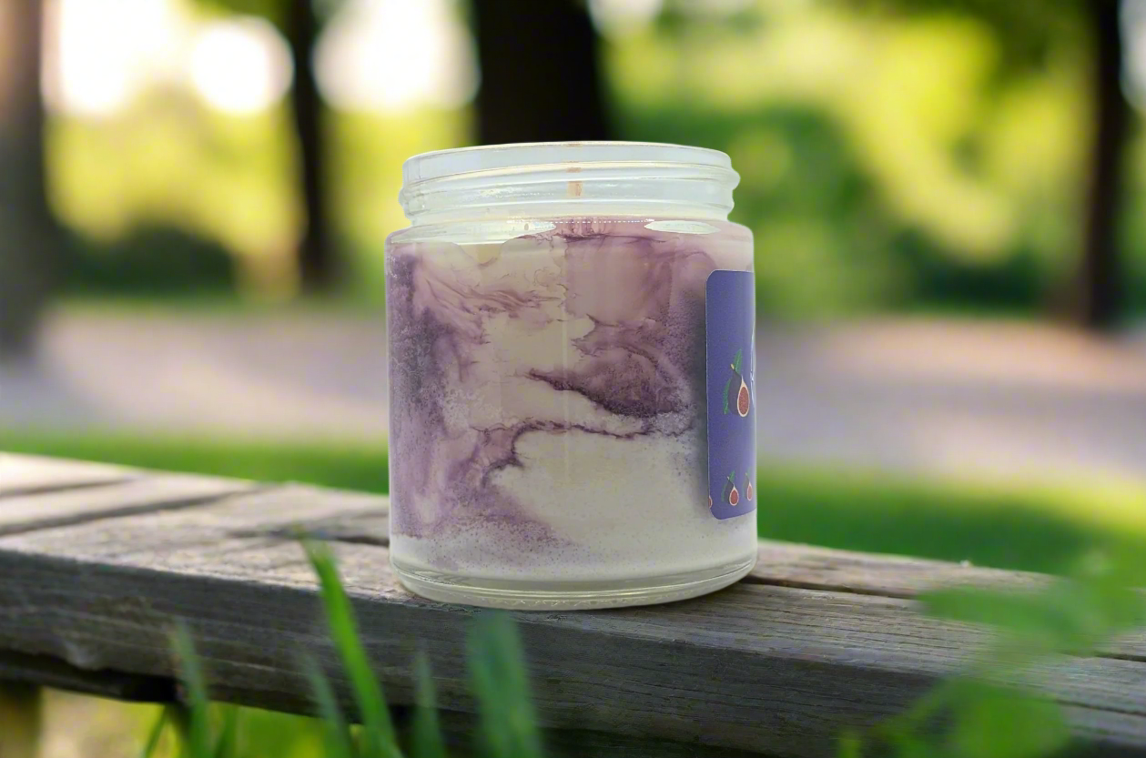 Candle in a glass jar with a purple and white marbled design on a white background