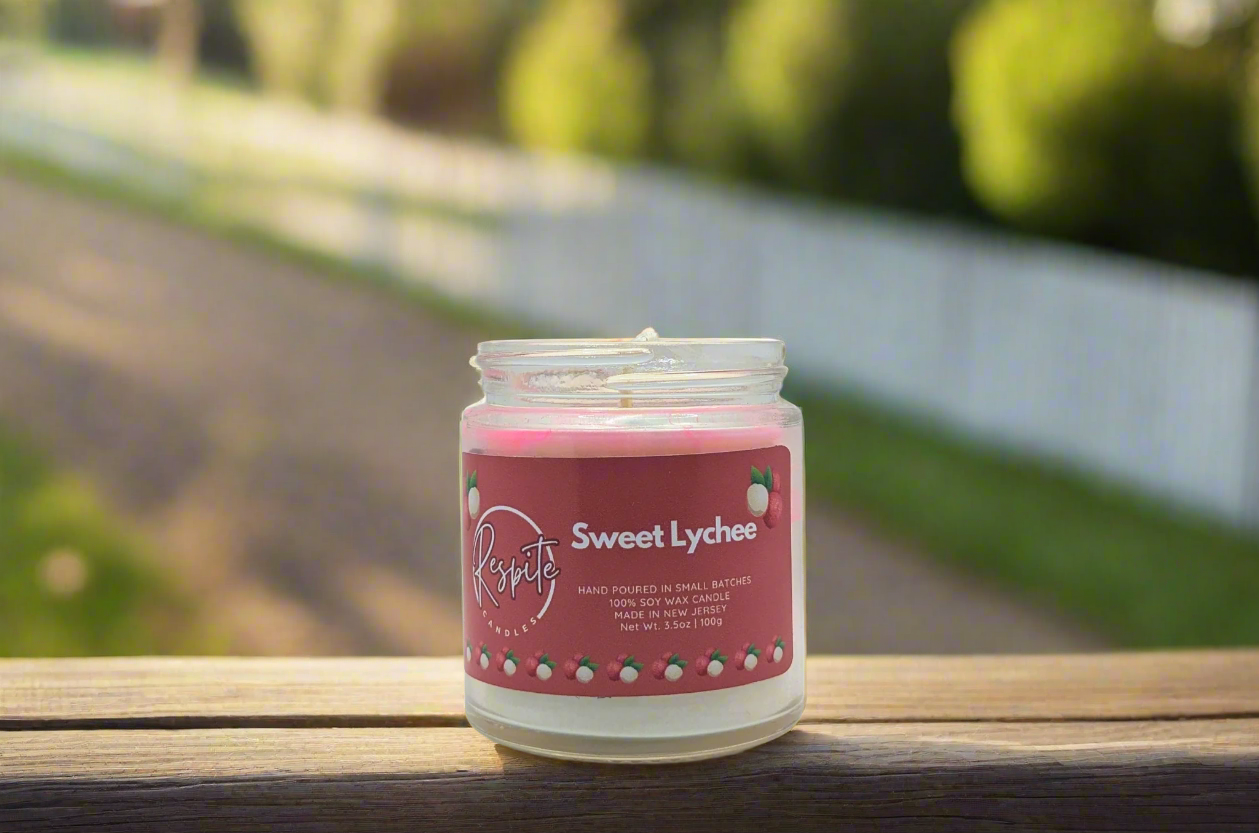 Candle in a glass jar with a pink label on a white background