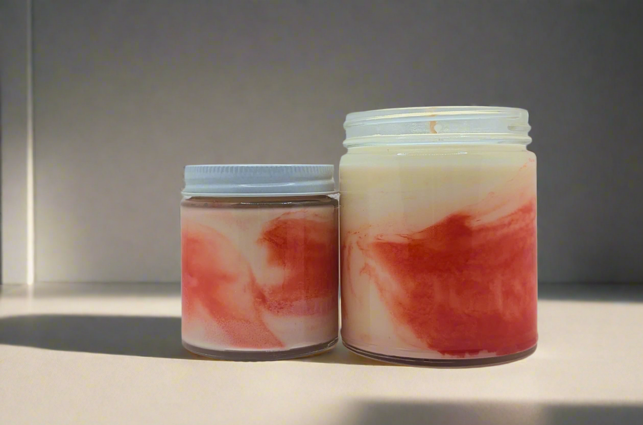 Two jars with marbled red and beige design on a white background