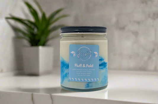 Candle jar with blue and white label on a white background