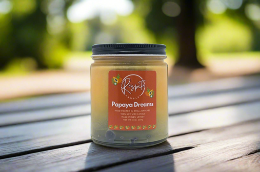 Candle jar labeled 'Papaya Dreams' with a visible brand logo on a white background