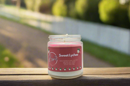Candle in a glass jar with a pink label on a white background
